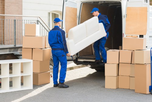 Professional movers carrying furniture from a home in Enfield